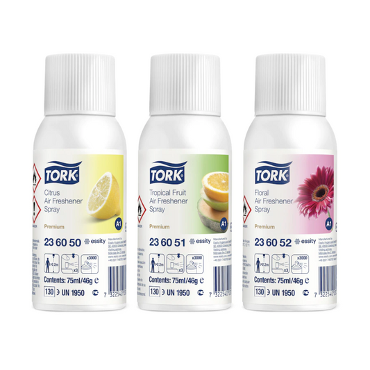Drei Tork 236056 Lufterfrischer Sprays im Mixed Pack (Citrus, Tropical Fruit, Floral) mit passenden Motiven auf weißem Etikett – ideal zur Geruchsneutralisierung und anhaltende Frische. Karton enthält 12 Flaschen.