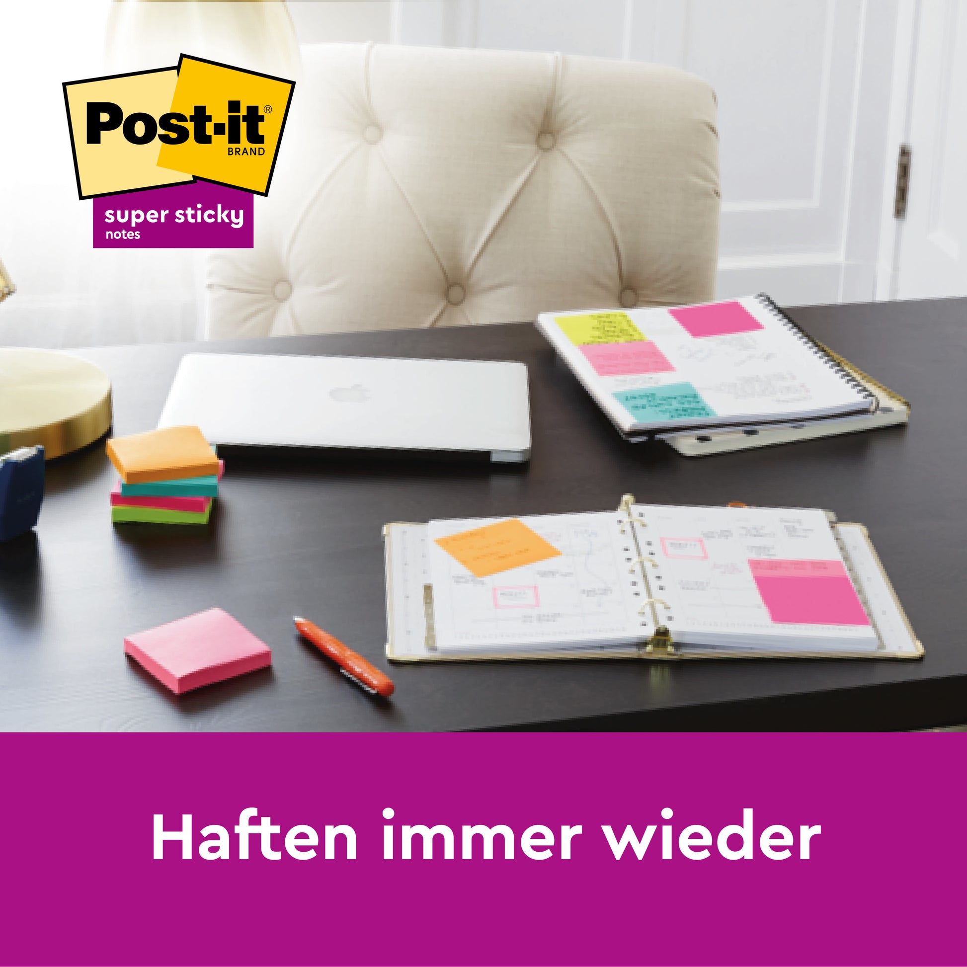 Ein Schreibtisch zeigt einen Planer und ein Spiralheft mit bunten Post-it® Super Sticky 100 % Recycling Notes (76x76 mm, 70 Blatt/Block, 3M Deutschland GmbH), einen geschlossenen Laptop, gestapelte Haftnotizblöcke, einen Stift und eine Lampe. Text: "Haften immer wieder.