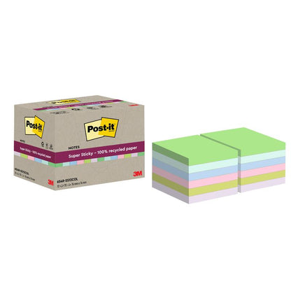 Tá bosca de Nótaí Athchúrsála 100% Super Sticky Post-it® (76 mm x 76 mm, 70 bileog/bloc, 100% PEFC) ón 3M Deutschland GmbH le feiceáil in aice le bloic ghlas, gorm, bándearg, buí agus corcra. Tá an pacáistiú maisithe le lógó 3M.