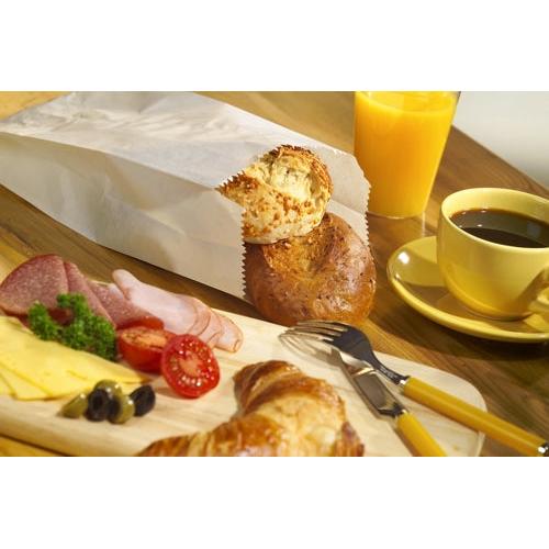 Ein Frühstücksaufstrich mit Käsescheiben, Aufschnitt, Oliven, Tomaten und Petersilie auf einem Holzbrett; ein Croissant; PAPSTAR 1000 Papierfaltenbeutel-Brötchen der PAPSTAR GmbH; Kaffee; Orangensaft; und Besteck auf einem Holztisch.