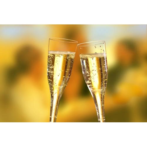 Two Starpak 50 stem glasses (tops) for champagne, PS 0.1 l crystal-clear, are raised for a toast, highlighting their clear design with lively bubbles against a softly blurred, warmly lit background.