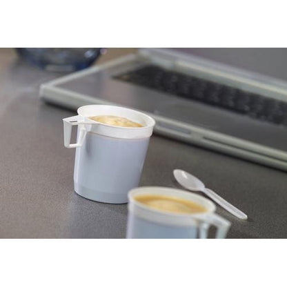 Two Starpak coffee cups (0.25 l, white, PS) from the pack of 40 are filled and standing on gray; next to them a white plastic spoon and in the background a laptop keyboard as a hint of daily coffee enjoyment.