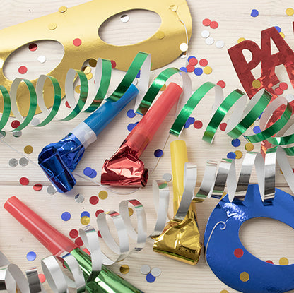 Partyartikel wie PAPSTAR GmbH Gesichtsmasken "Metallic" farbig sortiert (Beutel, 6 Stück), bunte Krachmacher, Bänder, Konfetti und ein "PARTY"-Schild sind auf einer hellen Holzfläche verstreut - perfekt für Ihre Feier!.