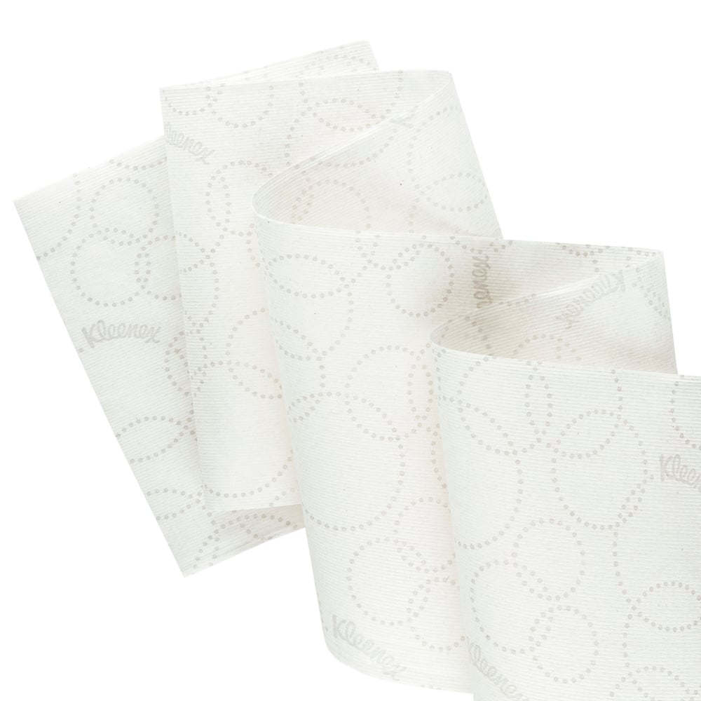 Close-up of a white Kleenex® Ultra™ Slimroll™ hand towel roll from Kimberly-Clark GmbH with a subtle dot pattern and partial unrolling to show its suitability for narrow dispensing systems; 6 rolls per carton.