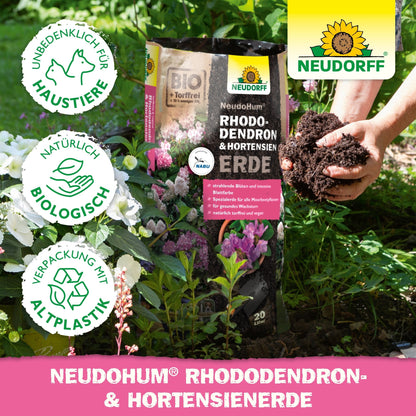 A person with rich NeudoHum Rhododendron & Hydrangea Soil from the Neudorff Shop, ideal for promoting the healthy growth of rhododendrons.