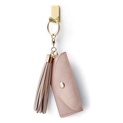 A pink faux leather key case with a golden snap button and matching tassel hangs on a 3M Command™ Metal Hook Size S, gold color (17032BR-4ES) on a golden key ring.