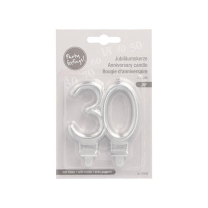 A package from PAPSTAR GmbH contains two anniversary candles with holder (7 cm, silver) in the shape "30" for anniversaries, with multilingual packaging and a transparent plastic cover for easy use.