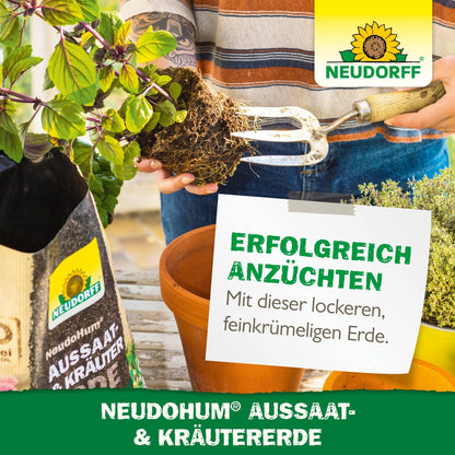 A person uses a garden fork to prepare the soil in a rectangular planter. Next to it stands a bag of NeudoHum Seed & Herb Soil from Neudorff Shop with Mediterranean herbs, herb plants, branding, and German advertising text.