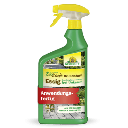 A green spray bottle labeled "Neudorff BioKraft Base Material Vinegar" from the Neudorff Shop, with yellow/white text, a yellow nozzle, and a red "Ready to Use" banner. The label shows paths and terraces for weed-free areas.