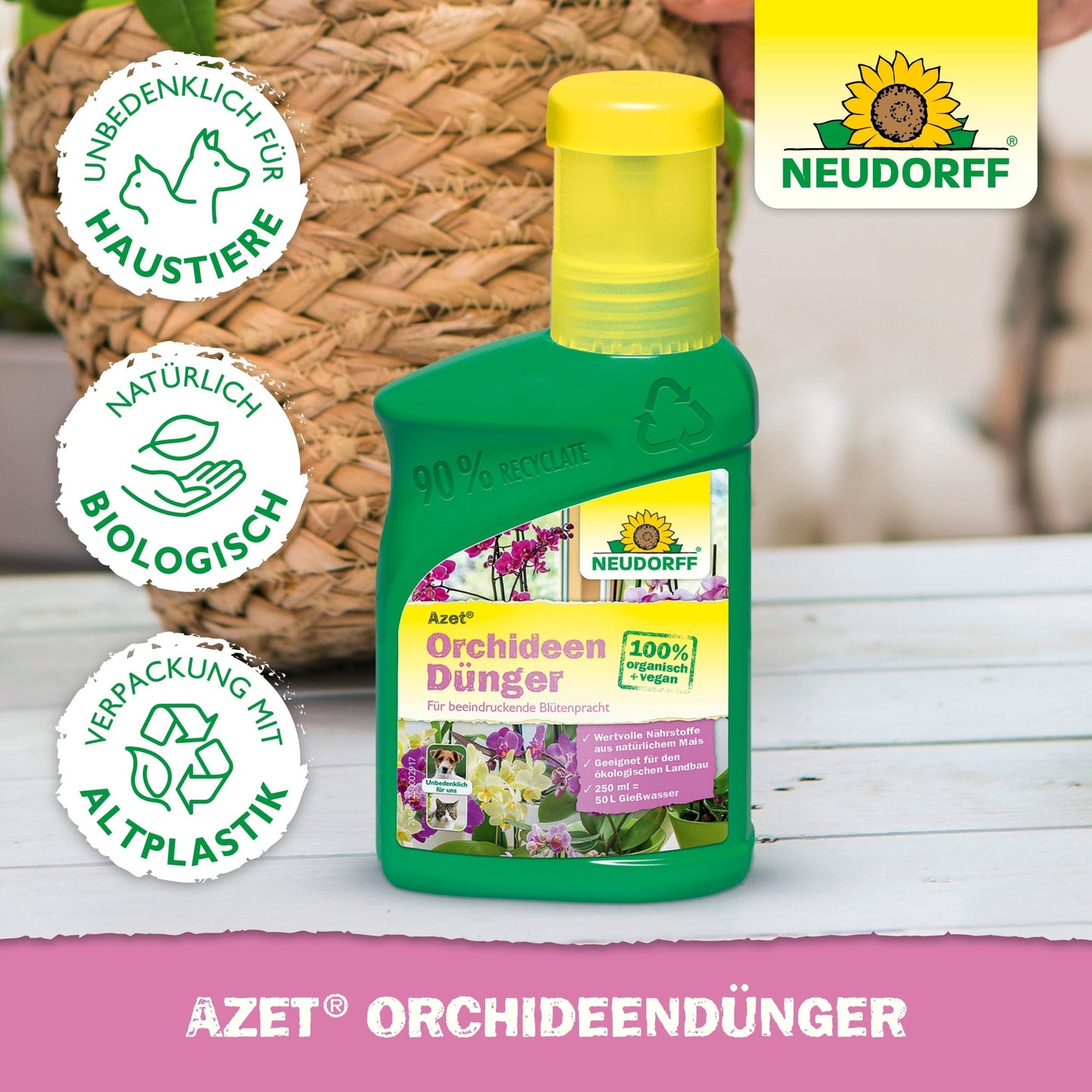 A green bottle of Azet Orchid Fertilizer liquid from Neudorff Shop stands on a pink surface. Its label made from 100% organic, pet-safe, recycled plastic promises magnificent blooms. In the background, a woven basket and a plant can be seen.