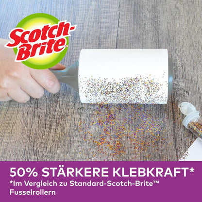 A hand uses the Scotch-Brite™ Pet Extra Sticky* Roller for pet hair by 3M Deutschland GmbH (48 sheets) to remove spilled glitter from a wooden surface. German advertisement: 50% stronger adhesion than standard models.