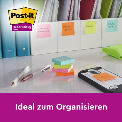 Multiple stacks of 3M Post-it® Super Sticky Notes (76x127 mm, 90 sheets/block, 100% PEFC) lie on a desk with pens, a folder, and files labeled with sticky notes. The text reads "Ideal for organizing" above the Post-it logo.