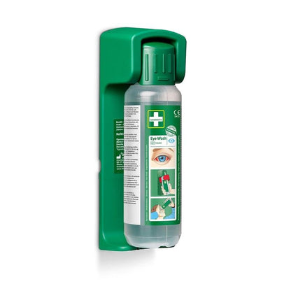 The Orkla Wound Care AB wall mount (for eye wash 500 ml) contains a glow-in-the-dark instruction sign and securely holds a clear eye wash bottle with usage instructions and diagrams. The package contains 1 piece.