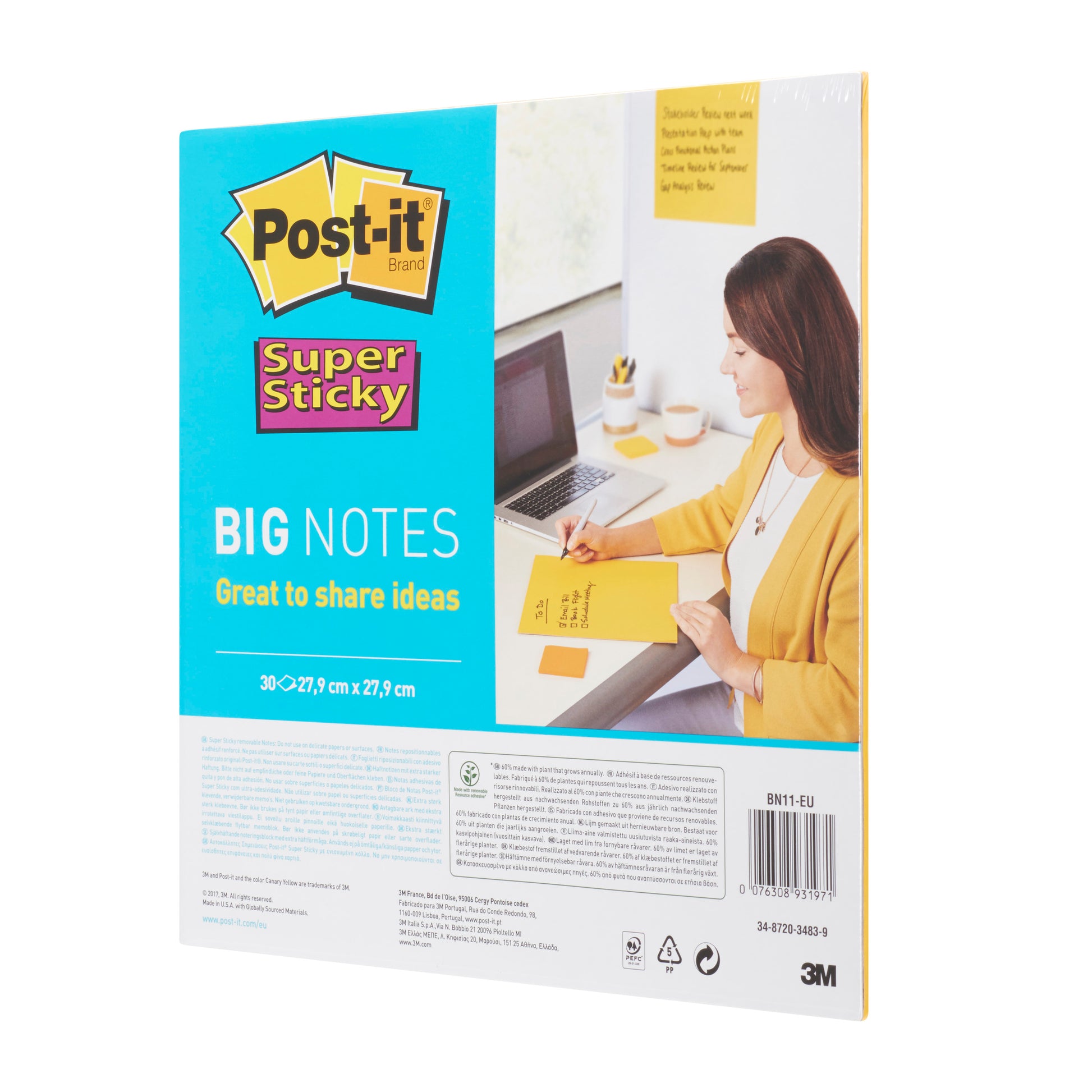 Abgebildet ist eine Packung Post-it® Super Sticky Big Notes BN11-EU (gelb, 279 mm x 279 mm, 30 Blatt, 1 Block) der 3M Deutschland GmbH mit Produktinformation und Branding. Eine Frau schreibt auf einem großen gelben Zettel an einem Schreibtisch mit einem Laptop.