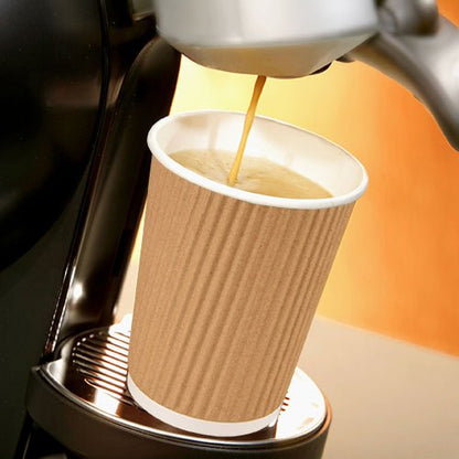 A coffee machine pours coffee into a Starpak 25 drinking cup, a paper “To Go” Ripple Wall cup on the metal drip tray, against a warm-toned background.