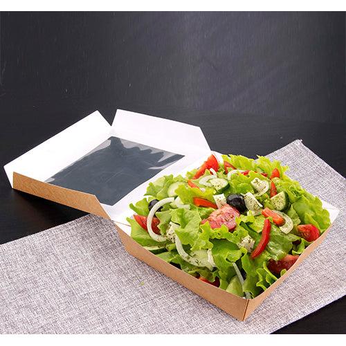A PAPSTAR 25 gourmet box made of cardboard with a PLA window from PAPSTAR GmbH presents fresh salad with vegetables and dressing, arranged on a gray, woven placemat against a dark background.