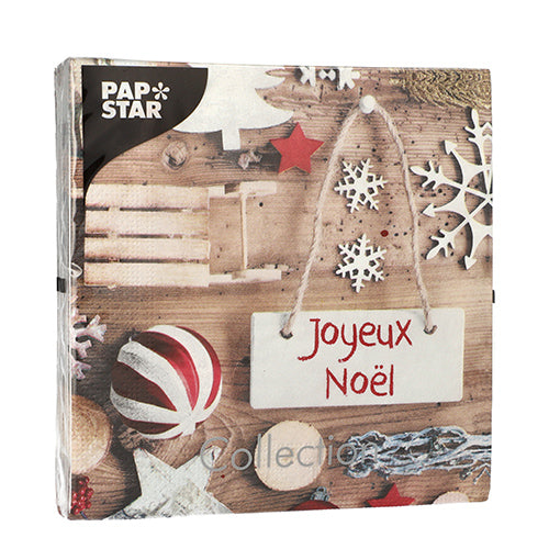 PAPSTAR 20 Servietten, 33x33 cm, 3-lagig von PAPSTAR GmbH: quadratische Servietten mit weihnachtlichen Motiven - Holzschlitten, Sterne, Schneeflocken, gestreiftes Ornament und ein "Joyeux Noël"-Schild auf Holz. Markenlogo in der linken oberen Ecke.