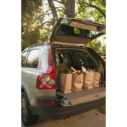 The open tailgate of an SUV reveals shopping bags secured with Scotch® Extremium™ INVISIBLE High-Performance Tape (20m x 48mm) from 3M. Sunlit trees brighten the driveway.