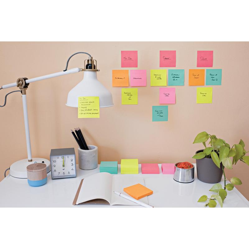 On the tidy desk are a lamp, a clock, a plant, stationery, and an open notebook. Above it, colorful 3M Deutschland GmbH Post-it® Super Sticky Notes (76 mm x 127 mm, 90 sheets/block) show handwritten tasks and reminders on the wall.