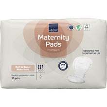 Eine Packung ABENA Maternity Pad, Premium von Abena Re-Seller GmbH enthält 15 weiche, saugstarke Einlagen für die Zeit nach der Geburt, deren Zertifizierungssymbole auf der Verpackung sichtbar sind.
