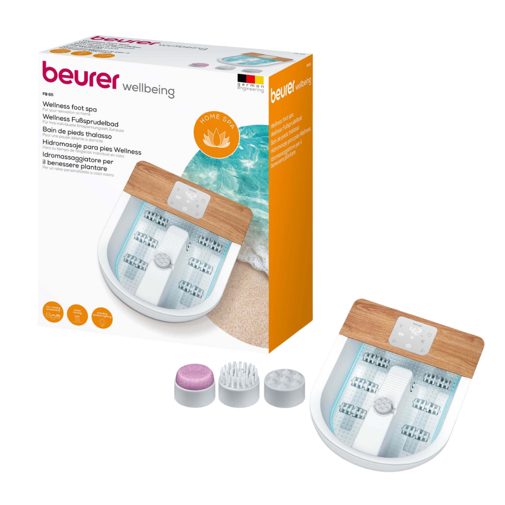An image of the Beurer FB 65 Wellness foot spa from Beurer GmbH shows the foot spa with modern features and a wooden accent, next to a picture of the sea on the packaging. Three interchangeable attachments are depicted on the front of the foot spa and its packaging, offering both vibration and bubble massage for ultimate relaxation.