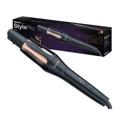 A Beurer HT 75 automatic curling iron from Beurer GmbH in an elegant black and rose gold design is seen along with its packaging box labeled "Glamour Curls." The automatic curling iron features digital controls on the handle and a 4-fold ion outlet. The box shows an image of the curling iron and the brand.
