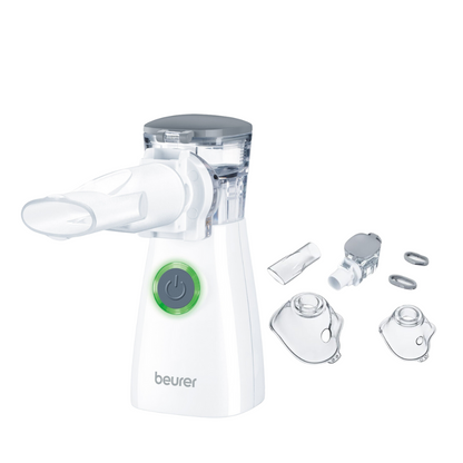 A white Beurer IH 57 inhaler with vibrating membrane technology from Beurer GmbH features a green power button. Next to it, various attachments, including masks in different sizes and connectors, are neatly arranged. The device has a transparent medication chamber and accessories that are perfectly suited for the efficient administration of inhaled medications.
