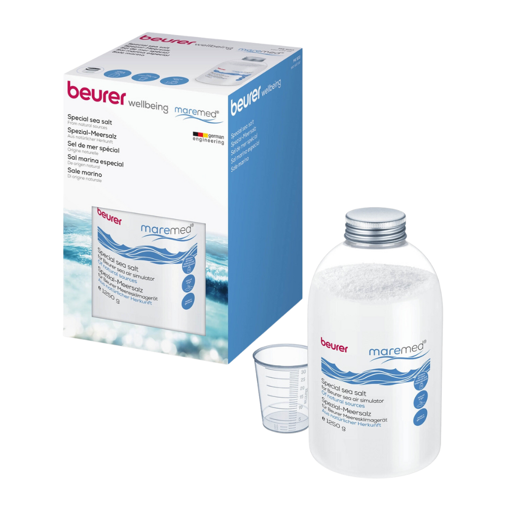 A product image shows a transparent plastic container filled with Beurer maremed® MK Special Sea Salt including measuring cup | Package (1 piece) and labeled with “Beurer GmbH”. Next to it, the packaging box shows the same brand and description in several languages. Next to the container, there is also a measuring cup.