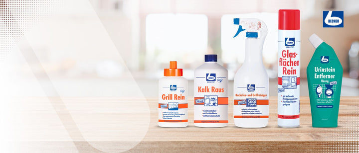 Eine Auswahl an Becher-Reinigungsprodukten, angeordnet auf einer Holzoberfläche. Die Produkte umfassen Grill Rein, Kalk Raus, Glasflächen Rein und Urinstein Entferner, jeweils in unterschiedlichen Behältern mit deutlich sichtbarem Becher-Logo. Der Hintergrund ist unscharf.