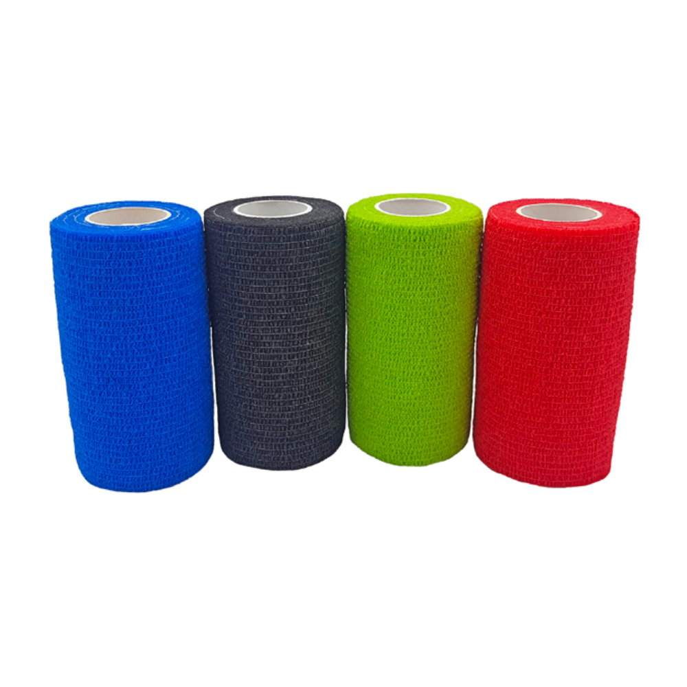 Four rolls of Holthaus VliVet® self-adhesive bandage for veterinary use from Holthaus Medical GmbH & Co. KG are lined up side by side. From left to right, the colors are blue, black, green, and red. The bandages have a textured surface and a cylindrical shape with a white inner core, ideal for hoof care in the veterinary field.