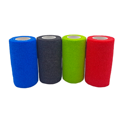 Four rolls of Holthaus VliVet® self-adhesive bandage for veterinary use from Holthaus Medical GmbH & Co. KG are lined up side by side. From left to right, the colors are blue, black, green, and red. The bandages have a textured surface and a cylindrical shape with a white inner core, ideal for hoof care in the veterinary field.