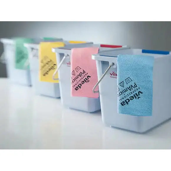 Four white cleaning buckets are lined up, each with a different colored Vileda Professional PVAmicro microfiber cloth hanging over the edge. The blue, pink, yellow, and green cloths from Vileda GmbH display different brand logos.