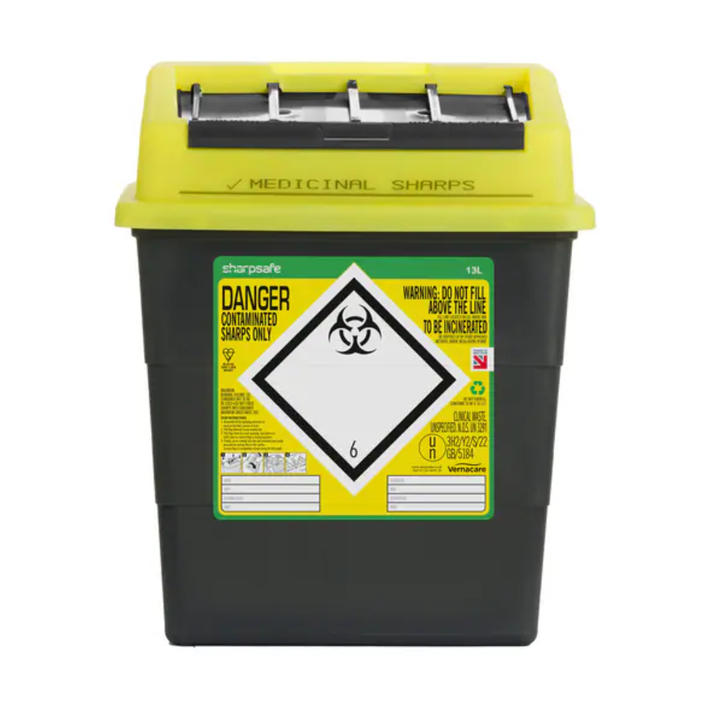 A yellow-black Sharpsafe disposal container for needles from Servoprax GmbH is equipped with a biohazard symbol and warning notices. The lid contains slots for the safe disposal of sharp objects with the text instructions "DANGER" and "DO NOT FILL ABOVE THE LINE. FOR INCINERATION".