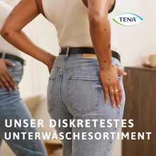Eine Person in einem weißen Tanktop und Blue Jeans steht mit den Händen in den Hüften und wird in einem Spiegel reflektiert. In der oberen rechten Ecke erscheint das TENA-Logo. Der Text lautet: „Unser diskretestes Unterwäschesortiment mit TENA Silhouette Plus Black Inkontinenzpants Gr. M für Blasenschwäche.“