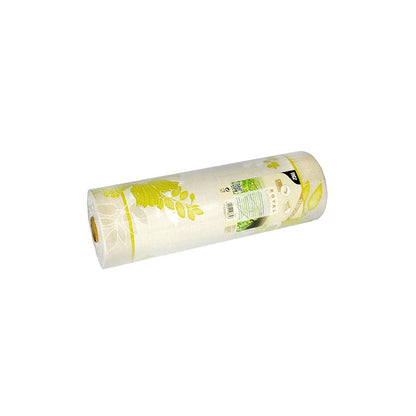 A table runner from the ROYAL Collection of PAPSTAR GmbH shows a floral pattern in yellow and green on a white background. The label is made of a PV-Tissue mix and contains text and product details. The roll leans slightly to the left.