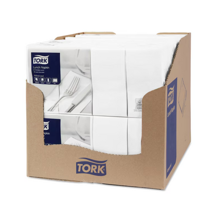 A box contains packs of Tork 477402 lunch napkins white 1/8-fold 2-ply. On the outside, product images and TORK branding can be seen. Inside, the neatly arranged white 1/8-fold napkins lie elegantly next to cutlery.