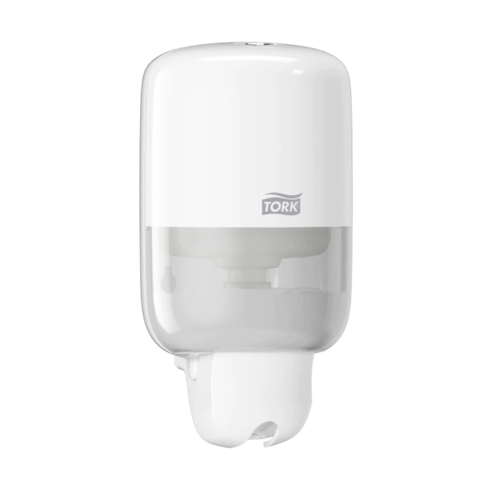 The Tork 561000 Mini Dispenser for Liquid Soap Elevation S2 from TORK - Essity Professional Hygiene Germany GmbH is a modern, white wall-mounted soap dispenser. It features a sleek design with a transparent lower part to display the liquid soap level, and the brand logo adorns the upper half.