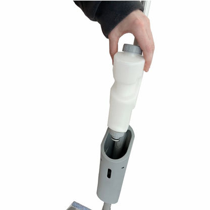 Eine Person setzt eine weiße Reinigungslösungsflasche in den Griff des Arcora Ultra Mobile Spray Mop Systems der Arcora International GmbH auf weißem Hintergrund ein.