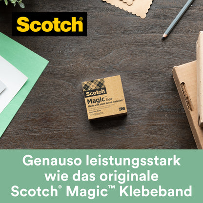 Eine Schachtel Scotch® Magic™ Klebeband (19 mm x 30 m, 1 Rolle, mit 66 % pflanzlichem Klebstoff von 3M Deutschland GmbH) liegt auf einem Holztisch neben grün-weißem Papier, einem Stift und einer Notizkarte. "Genauso leistungsstark wie das originale unsichtbare Klebeband.