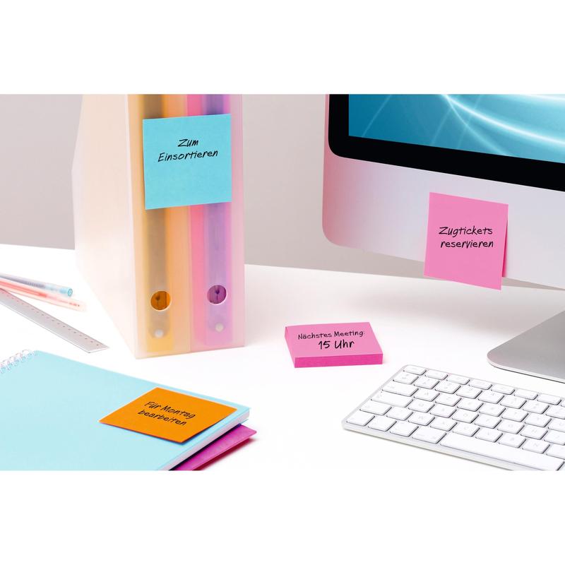 A desk scene with pastel-colored folders, notebooks, and 3M Post-it® Notes Yellow (76x76 mm, 90 sheets/block, 6 blocks, 100% PEFC) attached to office supplies and a monitor, next to a white keyboard and a blue screen.
