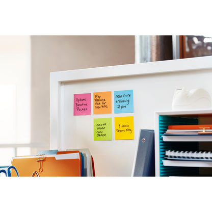Auf einer weißen Bürotrennwand stehen sechs bunte Post-it® Super Sticky Z-Notes (14 Blöcke + 2 Gratis, verschiedene Farben, 76x76 mm, 90 Blatt/Block, von 3M Deutschland), Ordner, ein blauer Organizer mit Dokumenten und ein Klebebandabroller.