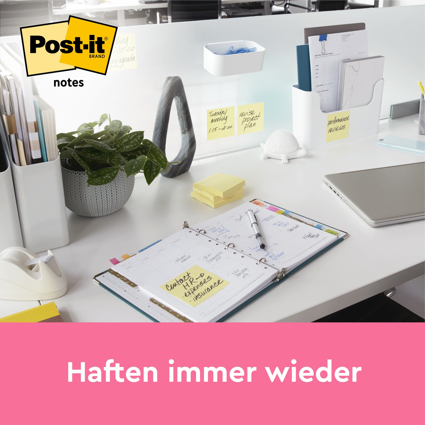 Ein aufgeräumter Bürotisch mit Planer, Stifthalter, Laptop, Pflanze und mehreren Post-it® Super Sticky Z-Notes Promotion in Gelb (76 mm x 76 mm) von 3M Deutschland GmbH, die an Gegenständen befestigt sind. Das Post-it Logo ist oben links. Text: "Haften immer wieder.