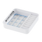 A square organizer made of white plastic with multiple compartments, ideal for storing medication, with a grid-like area for small items and a pen holder on the side. The grid area is designed for the Melipul cup-tablet by Helmut Schwarz GmbH, complete with small round transparent lids for neat storage.